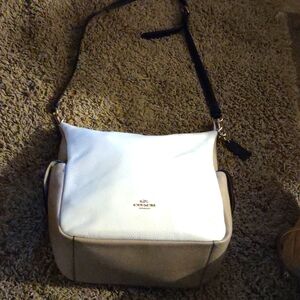 COACH zipper on the back side, and two side pockets that snap not a spot on it .